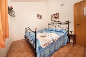 a bedroom with a bed with a blue and white blanket at Agriturismo Girolomoni - Locanda in Isola del Piano +25 photos