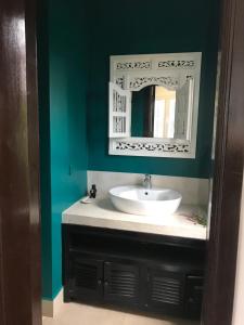 un bagno con lavandino e specchio di Hotel La Java Bleue a Kampot
