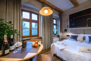 a bedroom with a bed and a table with a bowl of fruit at Piernikowe Apartamenty in Toruń