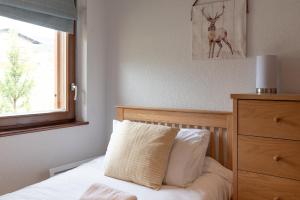 1 dormitorio con 1 cama con cabecero de madera y ventana en Apartment Rouge Gorge, en Les Gets