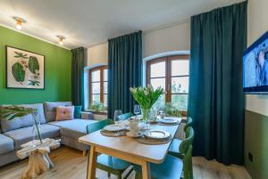 uma sala de estar com uma mesa e um sofá em Piernikowe Apartamenty em Toruń