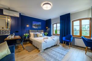 um quarto com paredes azuis, uma cama e uma secretária em Piernikowe Apartamenty em Toruń