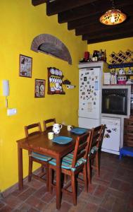 kuchnia z drewnianym stołem z krzesłami i lodówką w obiekcie `PRECIOSA CASA ANDALUZA CON VISTAS w mieście San Roque