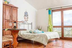 1 dormitorio con cama, mesa y ventana en Monolocale tra terra e mare, en Palau