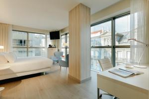 a hotel room with a large bed and a large window at Hesperia A Coruña Centro in A Coruña