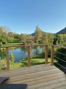 a wooden deck with a view of a lake at Gite La Bastide in Ornans