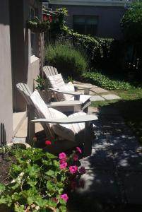 two white chairs sitting on a patio next to flowers at The Gift in Agulhas