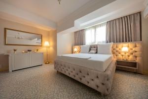 a bedroom with a large bed and a window at Hotel Casa Fiori in Bucharest