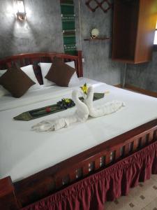 a bed with two swans made out of towels at Lanta Valom Hideaway in Ko Lanta