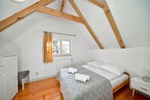 a bedroom with a bed with two towels on it at Leśny Domek koło Karpacza - Apartamentuj in Karpacz