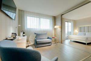 un salon avec un lit et un canapé dans l'établissement Hesperia A Coruña Centro, à La Corogne 24 autres photos