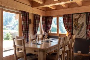 a dining room with a wooden table and chairs at Chalet Talini in Les Gets