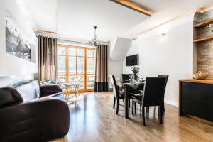 jadalnia i salon ze stołem i krzesłami w obiekcie Apartament Górski Deluxe Odkryj Zakopane w Zakopanem