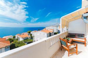 a balcony with a bench and a view of the ocean at Apartmani Villa Marija in Omiš