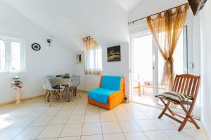 a living room with a blue chair and a table at Apartmani Villa Marija in Omiš