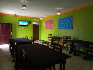een eetkamer met tafels en stoelen en groene muren bij Sipi Traveller's Lodge in Kapchorwa