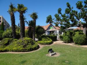 a house with palm trees and a bench in a yard at Campanile Marseille Saint Antoine in Marseille