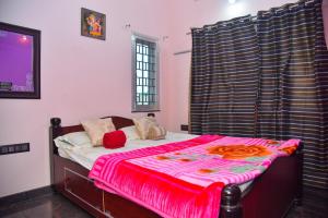 a bedroom with a bed with a red blanket on it at Gopi Homestay in Hampi