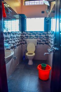 een badkamer met een toilet, een wastafel en een bad bij Gopi Homestay in Hampi