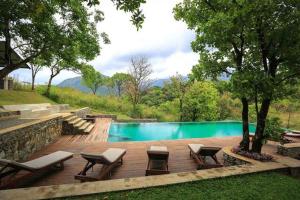 una piscina con sillas y una mesa junto a en Sennya Resorts, en Belihuloya