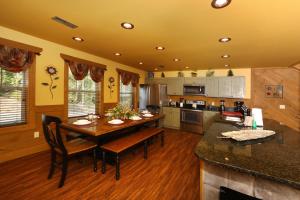 a kitchen with a wooden table and a dining room at Dive Right In chalet in Gatlinburg +61 photos