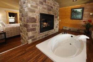 a bath tub in a room with a fireplace at Dive Right In chalet in Gatlinburg