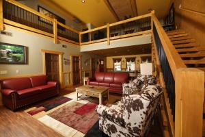 a living room with couches and a staircase at Dive Right In chalet in Gatlinburg