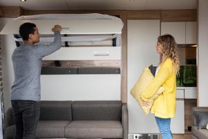 a man and a woman standing next to a bunk bed at Brighton Experience Freedom Glamping in Brighton & Hove