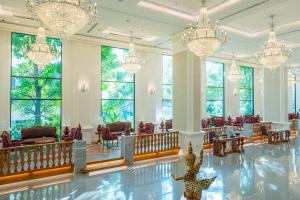 清邁的住宿－The Empress Premier Chiang Mai - SHA Extra Plus，大堂设有吊灯和桌椅