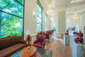清邁的住宿－The Empress Premier Chiang Mai - SHA Extra Plus，带沙发、椅子和窗户的客厅