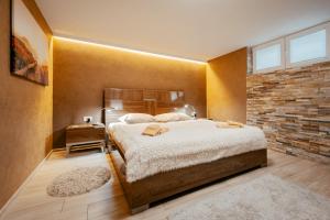 a bedroom with a large bed and a brick wall at Apartments in Villa Olimp in Ljubljana