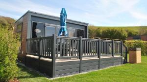 una casa pequeña con terraza y sombrilla en Brighton Experience Freedom Glamping, en Brighton & Hove