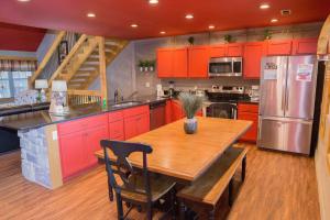 a kitchen with red cabinets and a wooden table at Serene Oasis chalet in Gatlinburg
