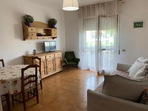 a living room with a table and a couch and a television at Holiday Villas in Marina di Massa