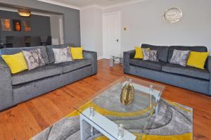 a living room with two couches and a table at The Croft, North Staffordshire in Blythebridge