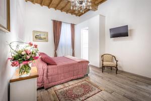 una camera con letto rosa e vaso di fiori di Arno Apartments a Firenze