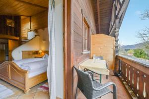 a balcony with a bed and a table and chairs at Jaudenhof - Apartment Seekaralm in Lenggries