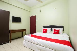 a bedroom with a large bed with red pillows at OYO 89549 Casavilla Hotel (city Centre) Taiping in Taiping