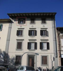 a tall white building with black shuttered windows at Your apartment in the Heart of Florence in Florence