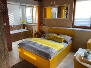 um quarto com uma cama amarela e uma banheira em Klinkierowy Apartament z wanną dla Dwojga em Gniezno