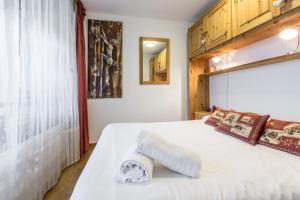 ein Schlafzimmer mit einem weißen Bett und einem Handtuch darauf in der Unterkunft Apartment Mummery 1 in Chamonix-Mont-Blanc