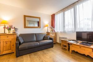 ein Wohnzimmer mit einem Sofa und einem TV in der Unterkunft Apartment Mummery 1 in Chamonix-Mont-Blanc