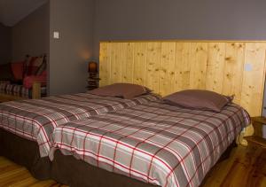 a bedroom with a bed with a plaid blanket at L'Arbre à Pain in Altier
