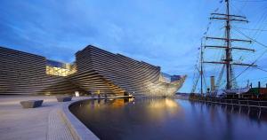 two tall buildings next to a river at dusk at Scotland Beds in Dundee