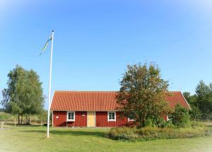 uma casa vermelha com uma bandeira em frente em Hagbards By Gårdspensionat em Slöinge