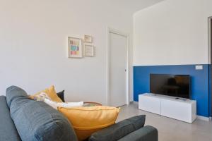 a living room with a couch and a tv at Urban House Carducci - Apartments in Turin