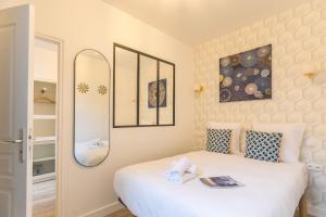 a bedroom with a white bed and a mirror at Apartments WS - Haut-Marais - Carreau du Temple in Paris