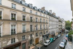 una strada cittadina con edifici e auto parcheggiati sulla strada di Apartments WS - Haut-Marais - Carreau du Temple a Parigi