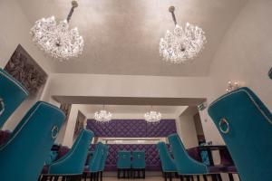 a room with blue chairs and chandeliers at Myo Hotel Wenceslas in Prague