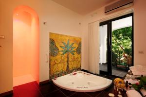 a bath tub in a room with a large window at Le Calette Bay in Cefalù